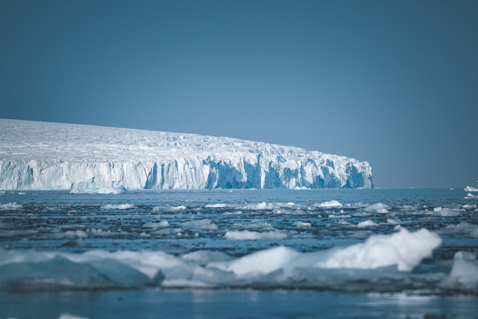 A tabular iceberg lit at dusk in the waters near the Antarctic Peninsula